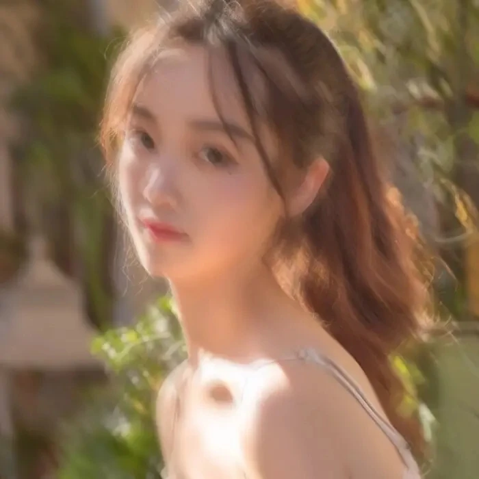 Original soft-focus portrait of a woman looking over her shoulder in warm sunlight